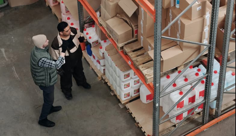 Two men in a warehouse discussing eCommerce logistics